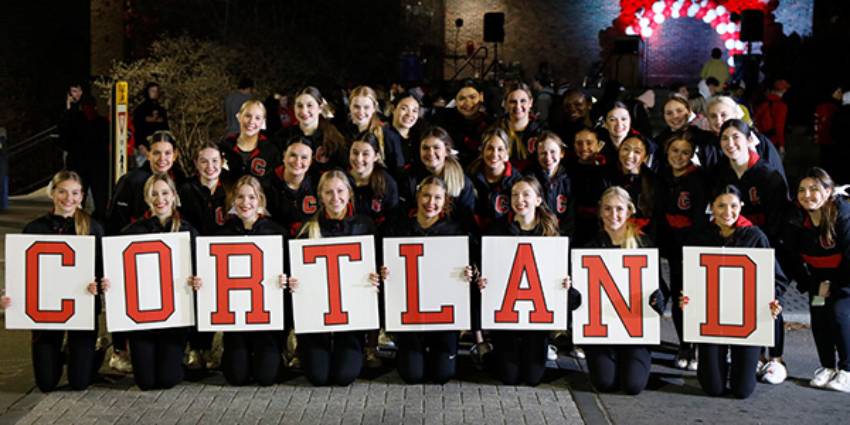 Cheerleaders holding Cortland letters